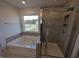 Bright bathroom with a soaking tub and a separate glass-enclosed shower at 150 Steppe Way, Garner, NC 27529