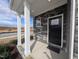 Front porch with stone accents, support columns, and a solid front door at 150 Steppe Way, Garner, NC 27529