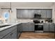 Kitchen with gray cabinets, stainless steel appliances, granite countertops, and hardwood floors at 174 Vega Loop, Sanford, NC 27330