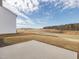 Expansive backyard with concrete patio, lawn, and views of the surrounding green space and trees at 199 Shelby Meadow Ln, Angier, NC 27501
