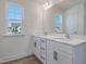 Bright bathroom featuring a double sink vanity with white cabinets and a large mirror at 199 Shelby Meadow Ln, Angier, NC 27501