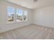 Bright bedroom featuring three large windows with neighborhood views and neutral carpeting at 199 Shelby Meadow Ln, Angier, NC 27501