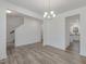 Open dining room featuring wood-look floors, modern chandelier and access to kitchen and stairway at 199 Shelby Meadow Ln, Angier, NC 27501