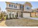 Two-story home featuring stone accents, dark shutters, and a convenient two-car garage at 199 Shelby Meadow Ln, Angier, NC 27501