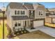 Charming two-story home featuring a stone facade, covered porch, and two-car garage at 199 Shelby Meadow Ln, Angier, NC 27501