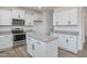 Bright kitchen showcasing white cabinets, stainless steel appliances, granite countertops, and a center island at 199 Shelby Meadow Ln, Angier, NC 27501