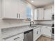 Modern kitchen boasts granite countertops, stainless steel dishwasher, and white cabinetry with black hardware at 199 Shelby Meadow Ln, Angier, NC 27501