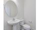 Stylish powder room featuring a pedestal sink, round mirror, and modern fixtures at 199 Shelby Meadow Ln, Angier, NC 27501