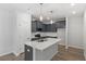 Modern kitchen featuring gray cabinets, stainless steel appliances, and a large island with a quartz countertop at 281 Chesapeake Commons St # 95, Garner, NC 27529