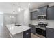 Contemporary kitchen featuring gray cabinets, stainless appliances, island with quartz countertop and pendant lighting at 281 Chesapeake Commons St # 95, Garner, NC 27529