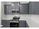 Modern kitchen features gray cabinets, stainless steel appliances, quartz countertops, and subway tile backsplash at 281 Chesapeake Commons St # 95, Garner, NC 27529
