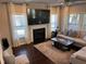 Well-lit living room with a fireplace, large windows, comfortable sofa and a decorative rug at 374 W Falcon Ct, Clayton, NC 27520
