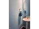 Stylish powder room with pedestal sink, round mirror, and decorative towel at 374 W Falcon Ct, Clayton, NC 27520