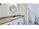 Modern bathroom with granite counters, black fixtures, round mirror, and open access to the shower at 414 S B Harrison Ln, Henderson, NC 27537