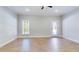 Bright bedroom with wood floors, ceiling fan, back patio access, and trim detail at 414 S B Harrison Ln, Henderson, NC 27537