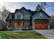 Charming two-story home featuring a stone facade, wooden accents, and a well-manicured lawn at 414 S B Harrison Ln, Henderson, NC 27537