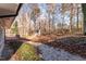 Gravel path that leads to a wooded backyard with leaves covering the ground at 6512 Johnsdale Rd, Raleigh, NC 27615