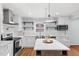 Bright, modern kitchen with white cabinets, stainless steel appliances, and a center island at 6512 Johnsdale Rd, Raleigh, NC 27615