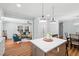 Open floor plan with a kitchen island and living space featuring hardwood floors and fireplace at 6512 Johnsdale Rd, Raleigh, NC 27615