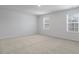 Spacious bedroom with neutral carpeting and two large windows at 70 Scenic Rock Dr, Youngsville, NC 27596