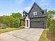 Charming gray home features a well-manicured lawn, a two-car garage, and inviting front porch at 734 S State St, Raleigh, NC 27601