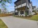 Stunning modern two-story home showcasing a spacious driveway and black-framed porch at 734 S State St, Raleigh, NC 27601