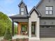 Inviting front porch with wood accent wall, seating, and stylish black trim, adjacent to the garage entrance at 734 S State St, Raleigh, NC 27601