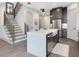 An open kitchen featuring a large island, staircase, and stainless steel appliances at 734 S State St, Raleigh, NC 27601
