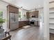 Open kitchen boasts stainless appliances, wood cabinets, and hardwood flooring for a modern aesthetic at 734 S State St, Raleigh, NC 27601