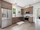 Open kitchen boasts stainless appliances, wood cabinets, and hardwood flooring for a modern aesthetic at 734 S State St, Raleigh, NC 27601
