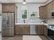 Kitchen features stainless appliances, wooden cabinets, and a cozy eat-in area with natural light at 734 S State St, Raleigh, NC 27601
