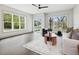 Bright living room with hardwood floors, ceiling fan, and plenty of natural light from large windows at 734 S State St, Raleigh, NC 27601