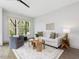 Bright living room with modern furniture, a ceiling fan, and plenty of natural light from large windows at 734 S State St, Raleigh, NC 27601