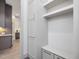 This mudroom features white cabinets with gold hardware, a built-in bench, and a view of the kitchen at 734 S State St, Raleigh, NC 27601