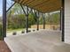 Covered outdoor patio with sleek black beams, concrete flooring, and a private view of the backyard at 734 S State St, Raleigh, NC 27601