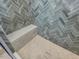 This shower features gray herringbone tile, a built-in bench, a mosaic tile floor, and a glass enclosure at 734 S State St, Raleigh, NC 27601