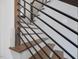 Close up of a modern staircase with wood steps and sleek black railings against light walls at 734 S State St, Raleigh, NC 27601