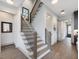 Modern staircase with wood steps, sleek black railings, and light walls leading to the upper level at 734 S State St, Raleigh, NC 27601