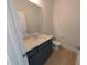 Half bathroom with dark vanity and light wood-look tile floor at 8 Steppe Way, Garner, NC 27529