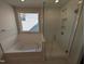 Bright bathroom featuring a shower and soaking tub under a window at 8 Steppe Way, Garner, NC 27529