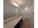 Bathroom with a combination tub and shower, dark vanity, and light wood tile flooring at 8 Steppe Way, Garner, NC 27529