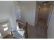 Upstairs hallway showcasing a carpeted floor, wood railing with iron spindles, and multiple doors at 8 Steppe Way, Garner, NC 27529