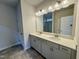 Bathroom featuring double sinks and a large mirror above a gray cabinet at 108 Commons Circle # 228, Clayton, NC 27520