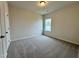 Bedroom with neutral walls, carpet flooring, and a window overlooking the neighborhood at 108 Commons Circle # 228, Clayton, NC 27520