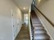 Hallway with doors and stairs with carpet runner and handrail at 108 Commons Circle # 228, Clayton, NC 27520
