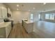 Bright, open kitchen featuring an island, quartz counters, stainless appliances, and hardwood floors at 108 Commons Circle # 228, Clayton, NC 27520
