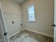 Tiled laundry room with shelving and a window at 108 Commons Circle # 228, Clayton, NC 27520