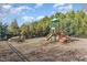 Community playground featuring a slide and picnic table surrounded by trees and mulch at 108 Commons Circle # 228, Clayton, NC 27520
