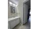 Bathroom featuring a vanity with a white cabinet, marble-look countertop, and large mirror at 1240 Teakwood Pl, Raleigh, NC 27606