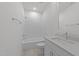 An all-white bathroom boasts a soaking tub, tiled shower, granite vanity, and sleek fixtures for a spa-like experience at 1721 Burnette Garden Path, Raleigh, NC 27612